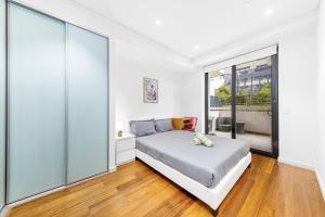a bedroom with a bed and a large window at Super comfy 2B Apt in Burwood in Sydney