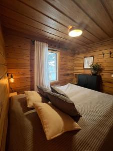 a bedroom with a bed in a wooden cabin at Hilltop Villa at Lake Porontima in Kuusamo
