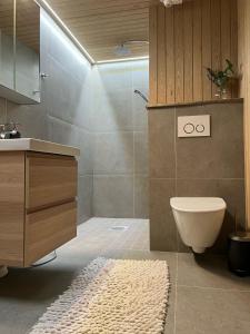a bathroom with a sink and a toilet and a rug at Hilltop Villa at Lake Porontima in Kuusamo +26 photos