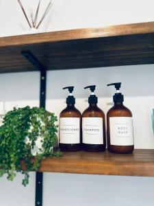 four bottles of soap sitting on a shelf at Happy Guest house in Newcastle in Minmi