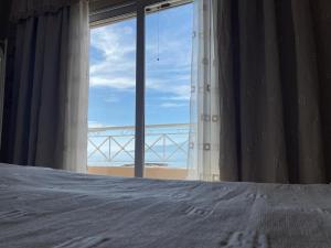een slaapkamer met een bed en uitzicht op de oceaan bij Seaview Apartments Alkis in Sarandë
