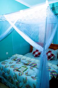 ein Bett mit einem Moskitonetz darüber in der Unterkunft Stay in Bomang'ombe with Breakfast in Moshi