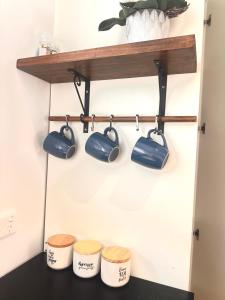 a shelf with pots and pans on a wall at Happy Guest house in Newcastle in Minmi