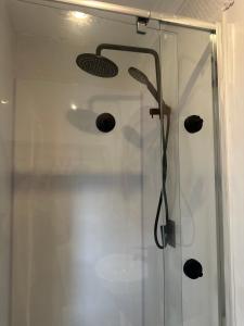 a shower with a glass door with a shower head at Happy Guest house in Newcastle in Minmi