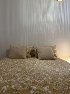 a bed with two pillows on top of it at Duplex Place du Martroi in Orléans