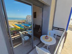 a balcony with a table and chairs and a view of the beach at Miramar Surf Anza in Agadir