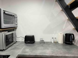 a living room with a microwave and a stove at Duplex Place du Martroi in Orléans