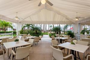 una sala da pranzo con tavoli e sedie in un tendone di Bahia Principe Luxury Bouganville - Adults Only All Inclusive a La Romana