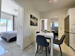 a bedroom with a bed and a white table and chairs at Dream Luxury Suites & Apartment in Pastida