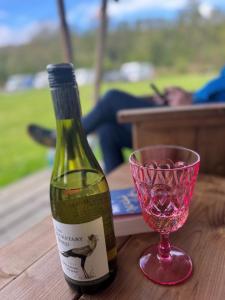 a bottle of wine and a pink glass on a table at Safari Tent in Pentewan