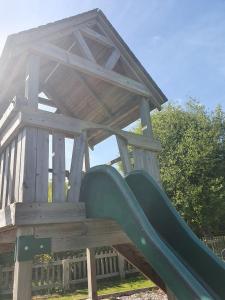 a playground with a slide on a wooden bench at Safari Tent in Pentewan