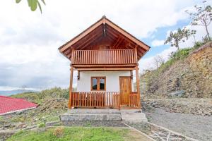 een klein huis op een heuvel met een veranda bij Capital O 93449 The Boekit Song Putri Resort in Wonogiri