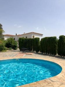 une grande piscine bleue en face d'une maison dans l'établissement Nuevespigas, à Casarabonela