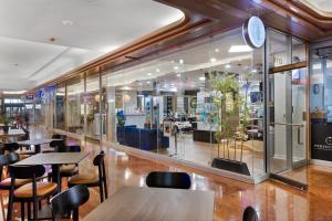 a restaurant with tables and chairs and a clock on the wall at Bayfront Gem with Balcony and Pool in Miami