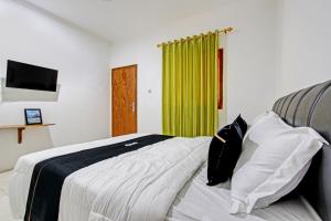 een slaapkamer met een bed en een groen gordijn bij Capital O 93449 The Boekit Song Putri Resort in Wonogiri