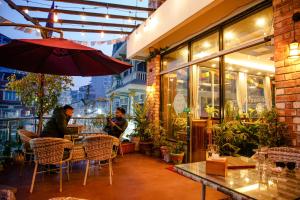 a restaurant with people sitting at a table with an umbrella at Hotel Edingo Inn in Itahari