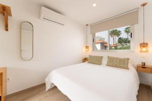 a white bedroom with a large bed and a window at Mangata Gran Canaria - Adults Only in San Agustin
