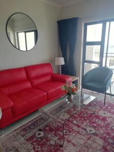 a red couch in a living room with a mirror at Ballito Splash in Ballito