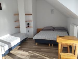 een slaapkamer met 2 bedden en een houten tafel bij Noclegi Pod Dębem in Skawina