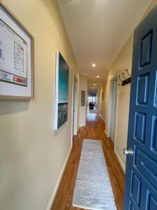 a hallway with a blue door and a rug at Award winning - Open plan Coastal Beauty in Patonga Beach - Pet Friendly in Patonga