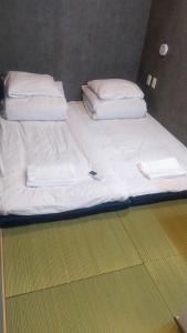 two beds with white sheets and a book on them at Hananogo Ikebukuro - Vacation STAY 16071v in Tokyo