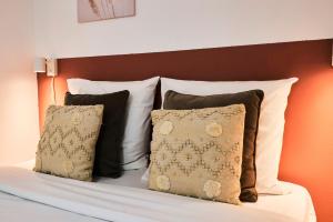 a bed with a bunch of pillows on it at Large studio between train station & Grand Place in Lille