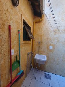 a small bathroom with a sink and a window at Villa Garoupeta - Apartamentos in Bombinhas