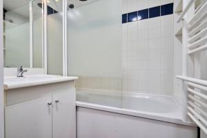 ein weißes Badezimmer mit einer Badewanne und einem Waschbecken in der Unterkunft Large studio between train station & Grand Place in Lille