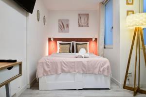 ein Schlafzimmer mit einem großen Bett mit einer rosa Decke in der Unterkunft Large studio between train station & Grand Place in Lille