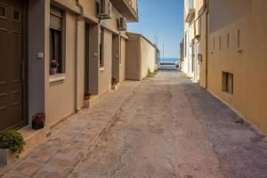 une ruelle vide entre des bâtiments avec l'océan en arrière-plan dans l'établissement Galini Studio, next to the beach, à Réthymnon