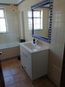 La salle de bains est pourvue d'un lavabo et d'un miroir. dans l'établissement Apartamento Vista Mar, à Cabanas de Tavira