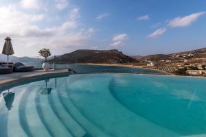 a swimming pool with a view of a mountain at Panormos Village Hotel in Mykonos