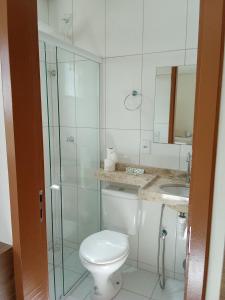 a bathroom with a toilet and a shower and a sink at Hotel Carvalho in Ibiapina