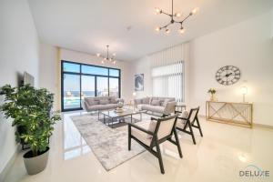 a living room with a table and chairs at Dazzling 4BR Villa with Assistant’s Room at Al Dana Villa Sharm, Fujairah by Deluxe Holiday Homes in Fujairah
