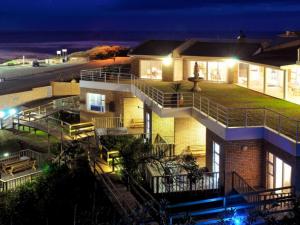 a house with a staircase leading up to it at night at Kelly's Beachfront Apartments in Port Alfred