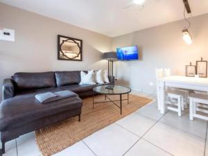 un soggiorno con divano e tavolo di Kelly's Beachfront Apartments a Port Alfred