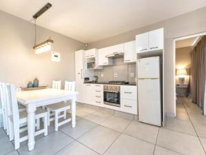 cocina con mesa blanca y nevera blanca en Kelly's Beachfront Apartments, en Port Alfred