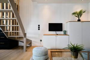 uma sala de estar com uma escada e uma televisão em Two bedroom house with courtyard, quiet em Saint-André