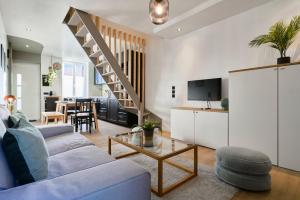 uma sala de estar com um sofá azul e uma mesa em Two bedroom house with courtyard, quiet em Saint-André