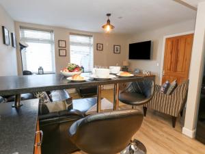 eine Küche und ein Wohnzimmer mit Tisch und Stühlen in der Unterkunft Anchor Cottage in Weymouth