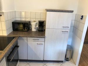 a kitchen with a refrigerator and a microwave at Ferienwohnung Monteurzimmer Heinzberg Haus Arnstadt in Arnstadt