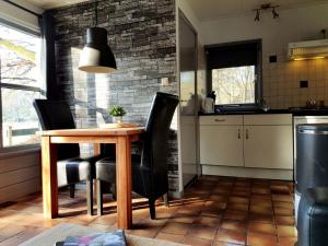 een keuken met een houten tafel en zwarte stoelen bij Tiny House de Berken in Otterlo