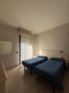 um quarto com duas camas e uma janela em Hotel Classicano em Ravenna