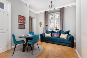 a living room with a blue couch and a table at Classy Old Town Suites in Krakow