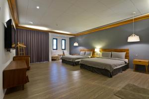 pokój hotelowy z dwoma łóżkami i telewizorem w obiekcie Kenting Cozy B&B w Kenting