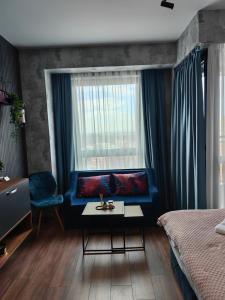 a bedroom with a blue couch and a window at Luxury Apartment/Studio in Plovdiv