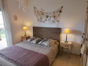 1 dormitorio con 1 cama con 2 lámparas en 2 mesas en Apartament a les cales de Llançà en residència privada amb piscina en Llança