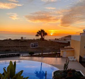un tramonto su una piscina con vista sull'oceano di Golden Suite Ocean View & Pool a Los Cristianos