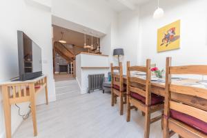 a dining room and living room with a table and a television at Tastefully decorated, family friendly property, central Kirkby Lonsdale, parking and EV charger in Kirkby Lonsdale