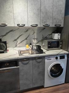 a kitchen with a washing machine and a sink at Luxury Apartment/Studio in Plovdiv